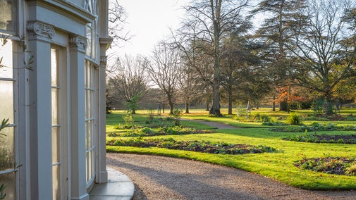 A view of the Garden House during winter, a white semi circular building with high arched windows supported by columns.